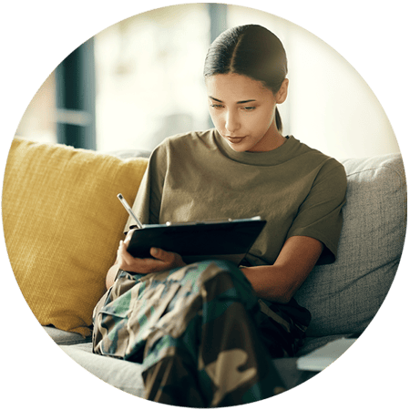 Woman sitting in a couch drawing on a tablet