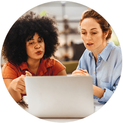 Two coworkers looking at a computer discussing their customer experience strategy