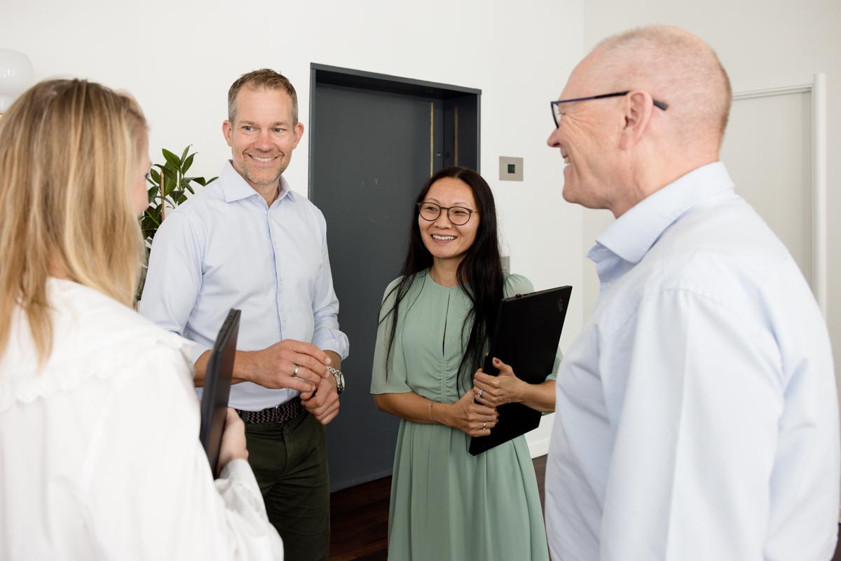 Four employees at KommuneKredit having a conversation at the office